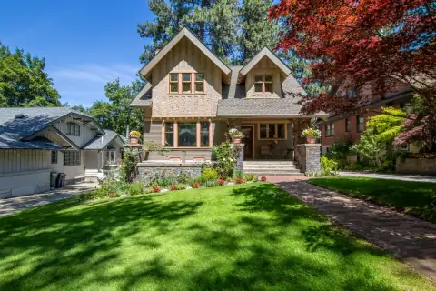 A craftsman-style home with a manicured lawn and landscaping