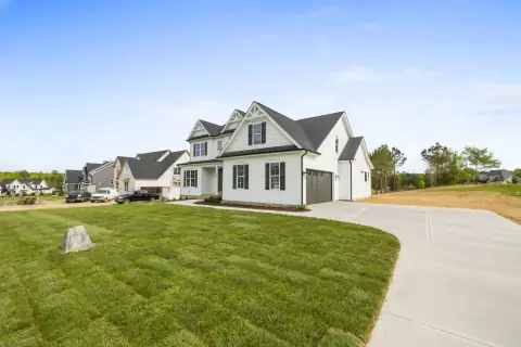 A suburban home with a striped lawn and clean driveway